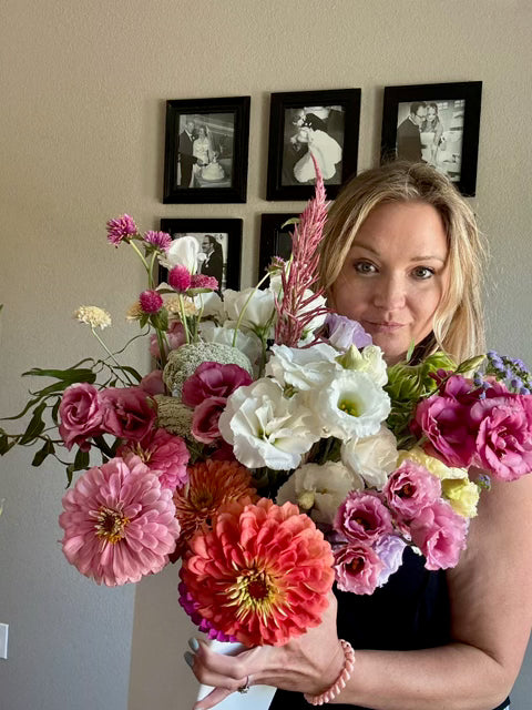 Leigh Rydell holding flowers in her Weatherford studio